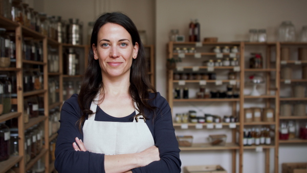 Young female owner of zero waste shop, looking at camera.