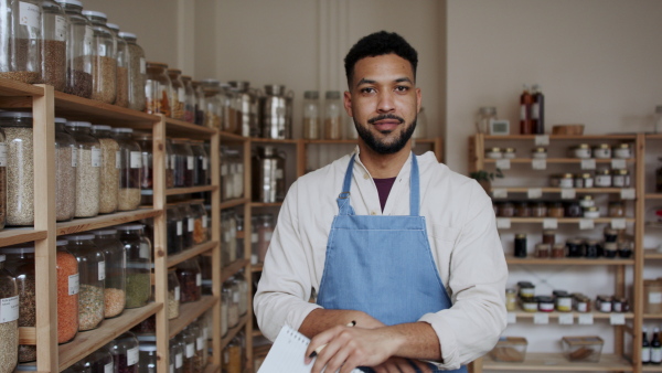 A male owner of zero waste shop, looking at camera.