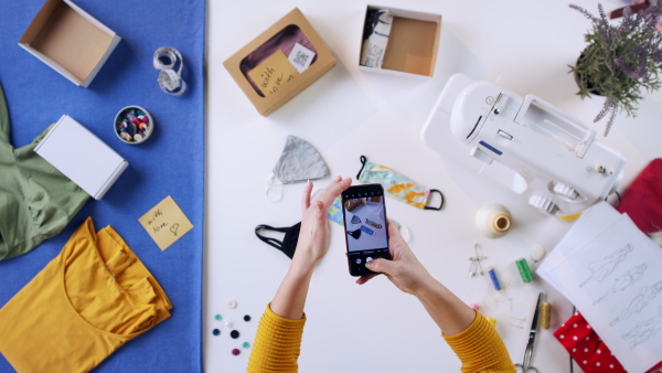 A top view of woman photographing diy facemasks, coronavirus desktop concept.