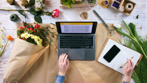 A top view of woman completing an order of flowers.