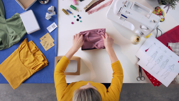 A top view of woman preparing a package, coronavirus desktop concept.