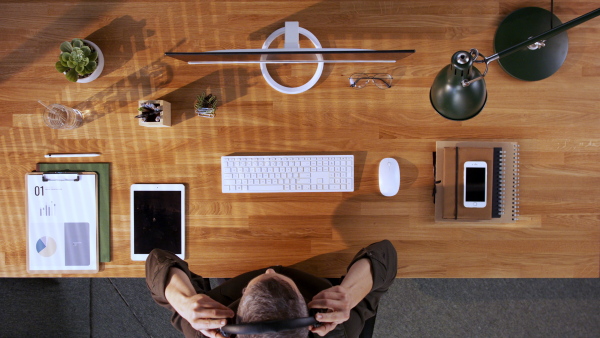 A top view of businessman working at desk, taking a break in home office.