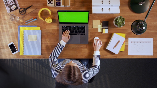 A top view of teenage student with laptop with green screen. Lockdown concept.