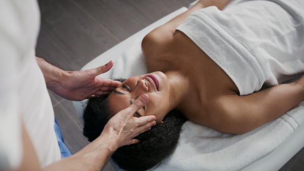 Young woman having relaxing head massage at the spa.