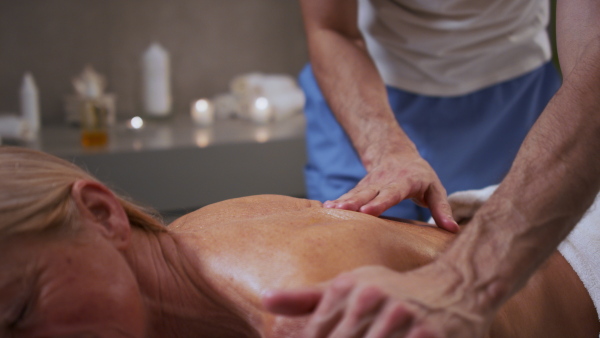 Senior woman having relaxing back massage at the spa.