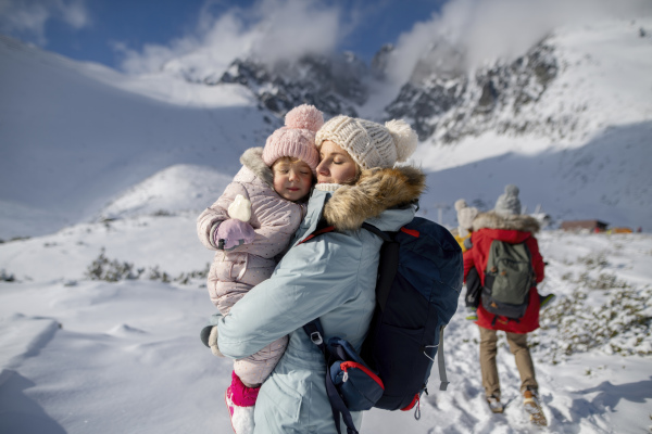 Family is enjoying winter holiday in the mountains, playing in snow.