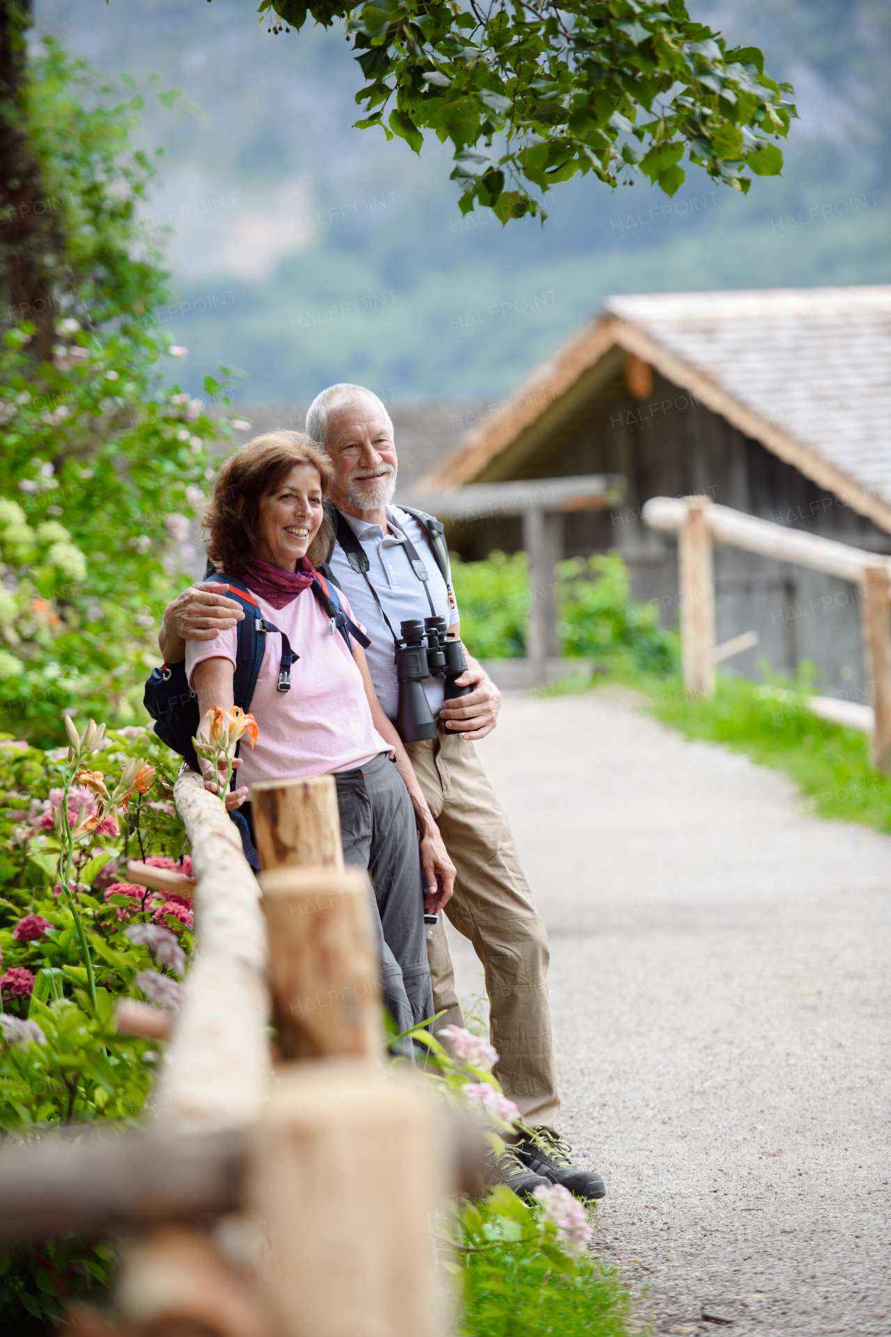 Active elderly couple on trip together, during early spring day. Senior tourists visiting, exploring new places. Sightseeing, holding hands.