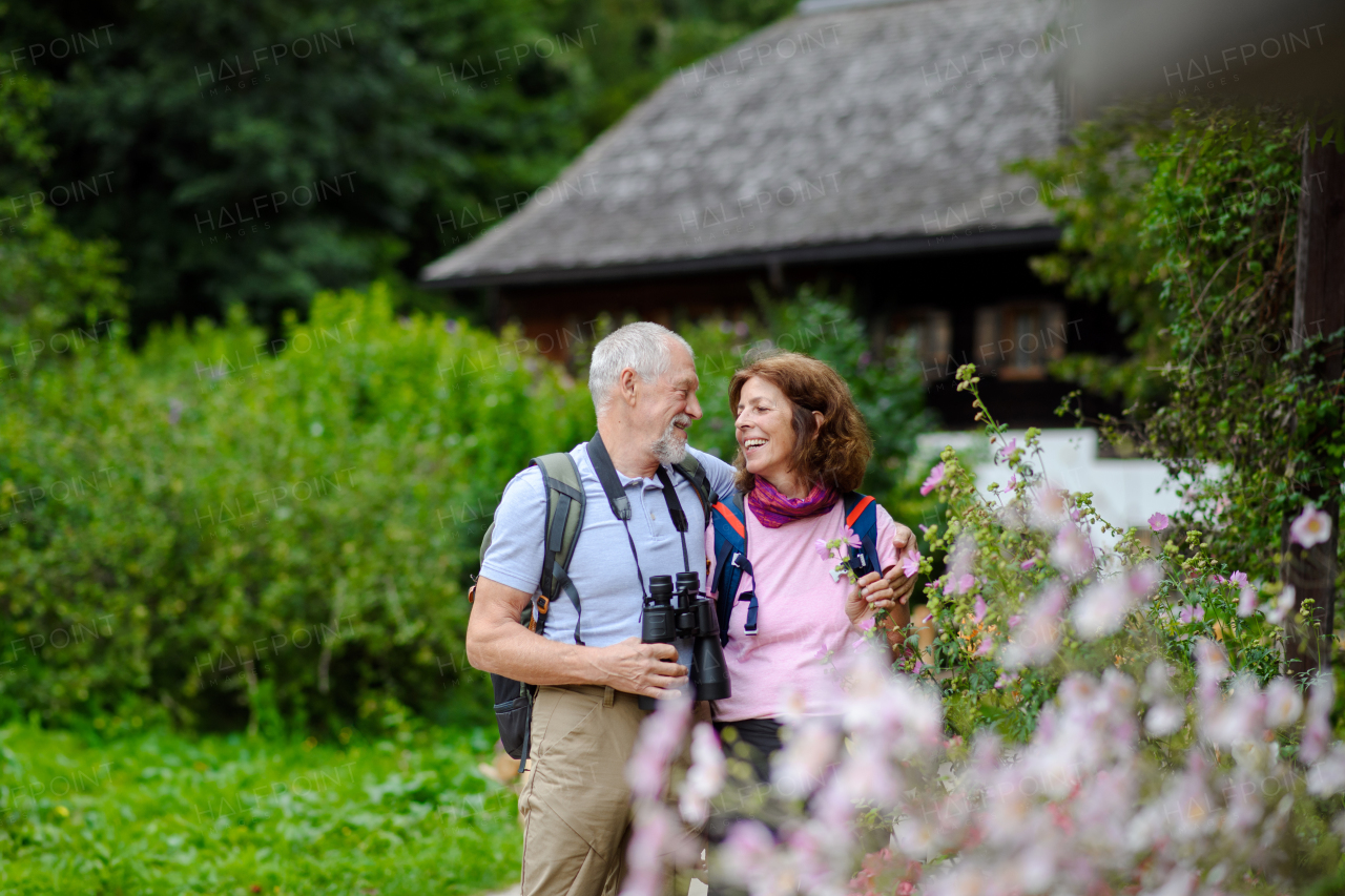 Active elderly couple on trip together, during early spring day. Senior tourists visiting, exploring new places. Sightseeing, holding hands.