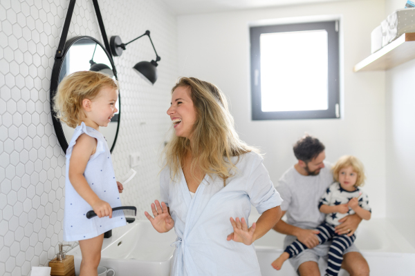 Parents and kids, having morning bathroom routine. brushing teeth and washing face, enjoying together time at home.