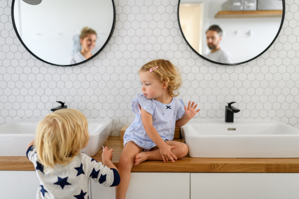 Parents and kids, having morning bathroom routine. brushing teeth and washing face, enjoying together time at home.