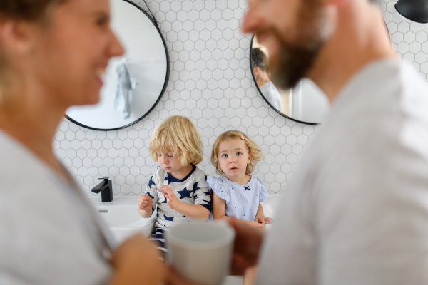 Parents and kids, having morning bathroom routine. brushing teeth and washing face, enjoying together time at home.