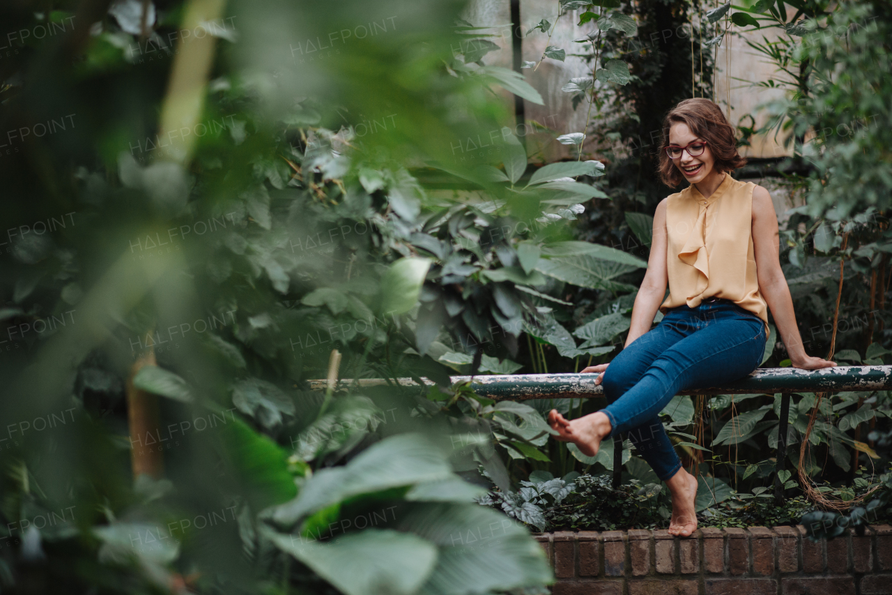 Beautiful woman sitting in botanical garden, meditating, connecting with nature.