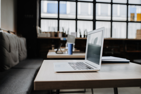 Coworking space, open-plan work area with desks and laptops. Concept of coworking, common workspaces for business, startups.. Working remotely from coffee shop.