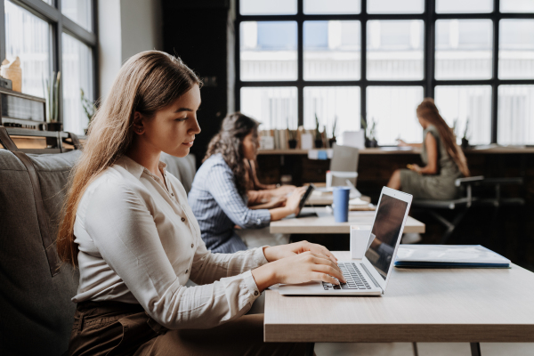 Group of freelancers and remote businesspeople working in shared work area. Concept of coworking, common workspaces for business, startups. Working remotely from coffee shop.