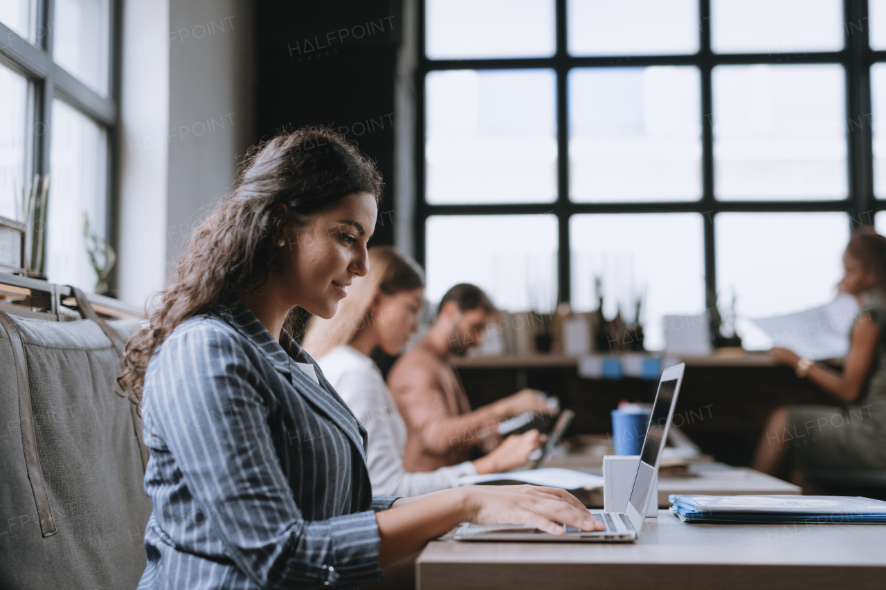 Group of freelancers and remote businesspeople working in shared work area. Concept of coworking, common workspaces for business, startups. Working remotely from coffee shop.