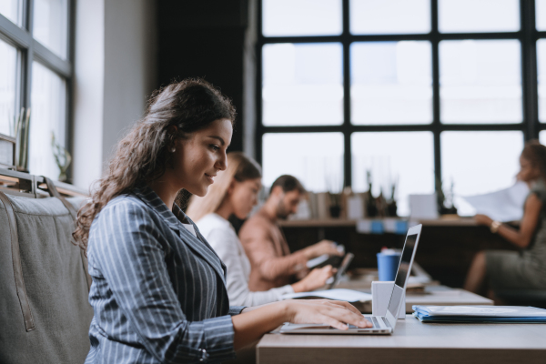 Group of freelancers and remote businesspeople working in shared work area. Concept of coworking, common workspaces for business, startups. Working remotely from coffee shop.