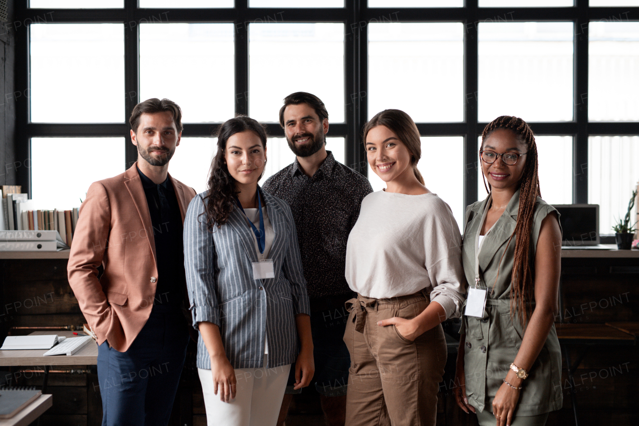 Group of colleagues standing in modern office, looking at camera. Concept of teamwork, diverse team for business, startups. Team portrait.