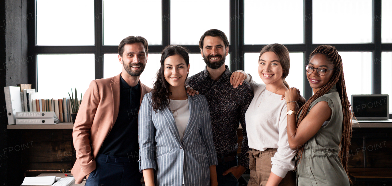 Group of colleagues standing in modern office, looking at camera. Concept of teamwork, diverse team for business, startups. Team portrait.