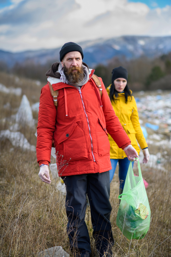 Group of activists picking up litter in the nature, environmental pollution, eco activism. and plogging concept.