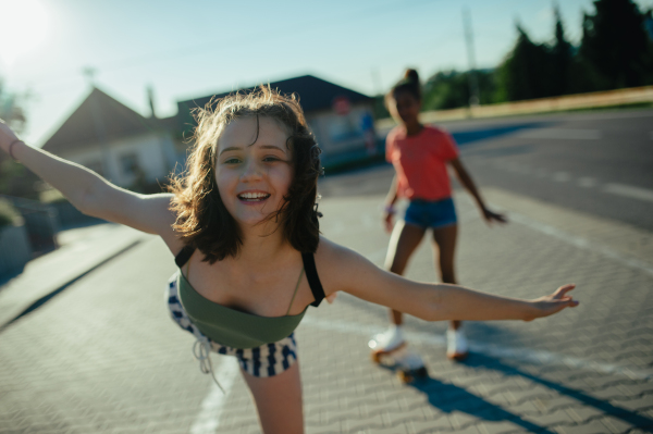 Young teenager girl best friends with skateboards spending time outdoors in city during warm summer holiday day.