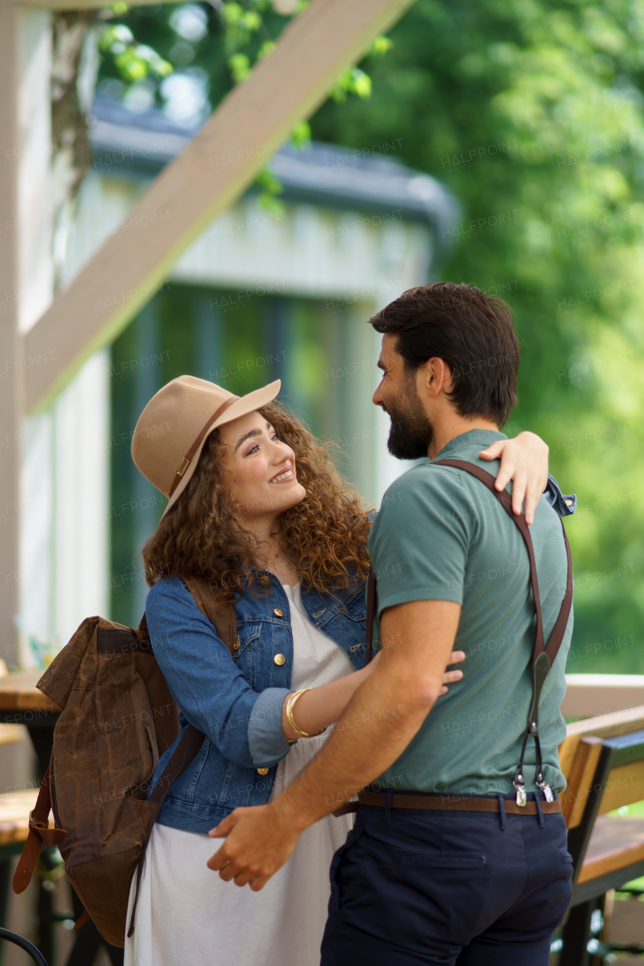 Friends meeting at a restaurant terrace. Greeting and hugging, after long time of not seeing each other. Concept of long-term friendships.