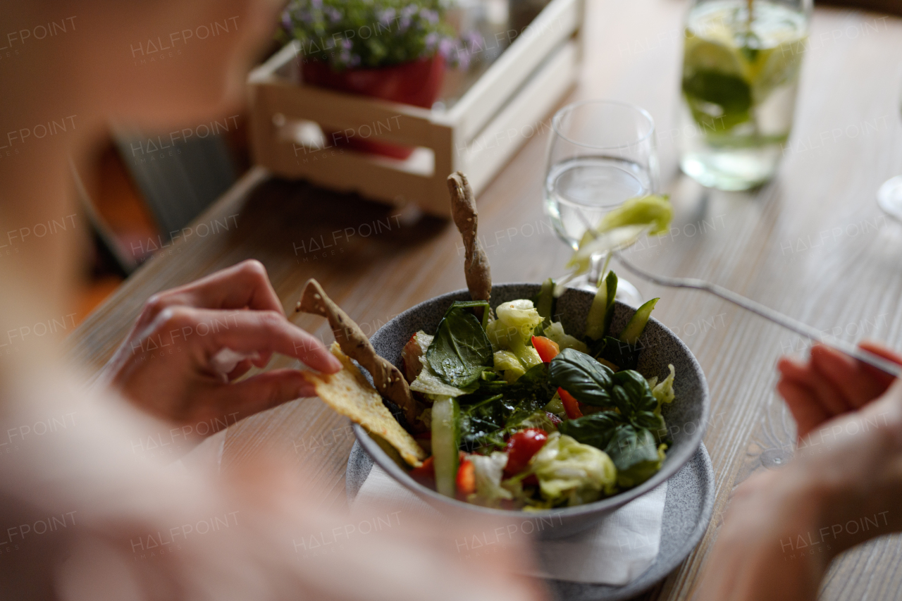 Close up of vegetable salad serving in restaurant, customer eating healthy food from china bowl.