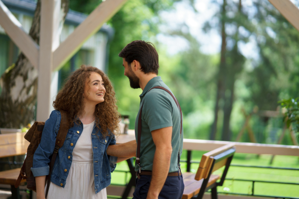 Friends meeting at a restaurant terrace. Greeting and hugging, after long time of not seeing each other. Concept of long-term friendships.