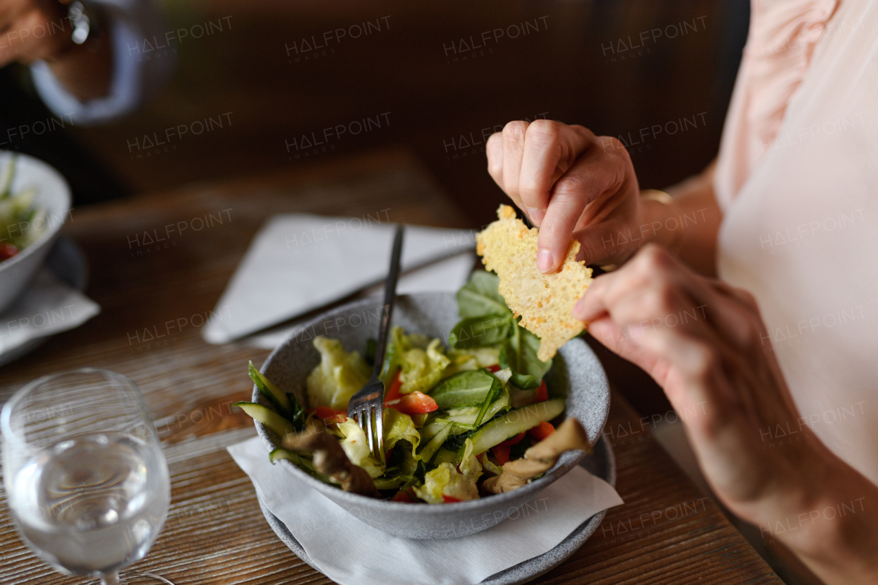 Close up of vegetable salad serving in restaurant, customer eating healthy food from china bowl.