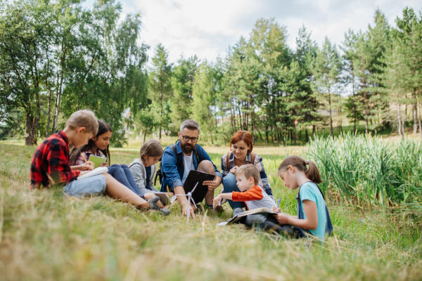 Students learning about renewable wind energy during field teaching class. Outdoor active education helping young student to learn about ecology and sustainability, Environmental conservation.