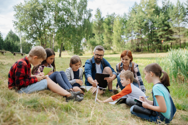 Students learning about renewable wind energy during field teaching class. Outdoor active education helping young student to learn about ecology and sustainability, Environmental conservation.