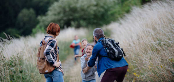 Young students having fun during biology field teaching class, running down the dirt path. Dedicated teachers during outdoor active education teaching about ecosystem, ecology and nature.