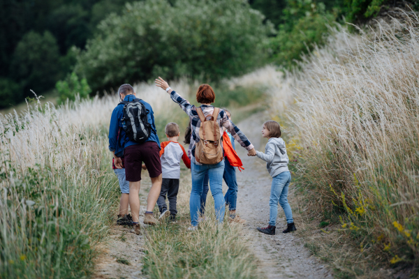 Young students having fun during biology field teaching class, running down the dirt path. Dedicated teachers during outdoor active education teaching about ecosystem, ecology and nature.