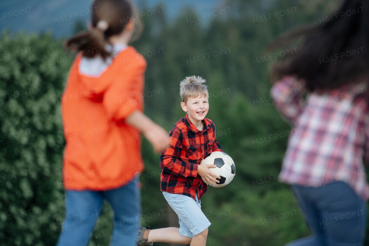 Young students playing with teacher outdoors, in nature, during field teaching class, running with ball, Dedicated teachers during outdoor active education.Teachers' Day.