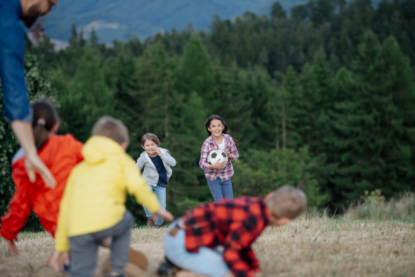 Young students playing with teacher outdoors, in nature, during field teaching class, having fun. Dedicated teachers during outdoor active education.Teachers' Day.