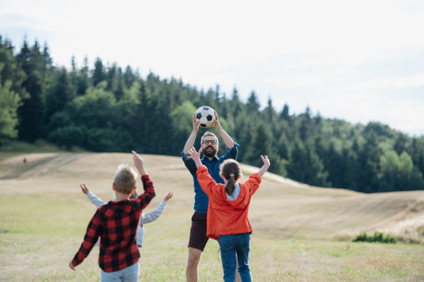 Young students playing with teacher outdoors, in nature, during field teaching class, running with ball, Dedicated teachers during outdoor active education.Teachers' Day.