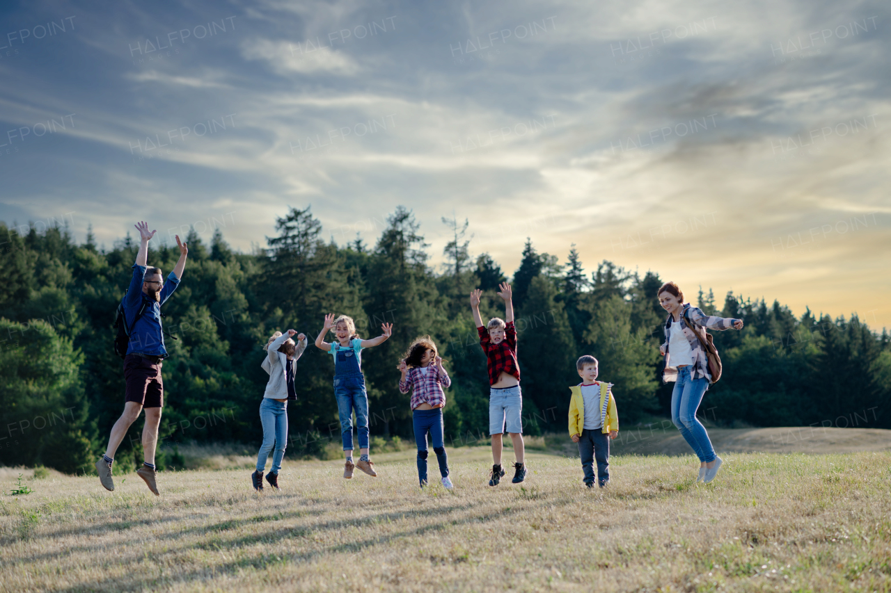 Young students walking across meadow during biology field teaching class, holding hands. Dedicated teachers during outdoor active education teaching about ecosystem and nature.