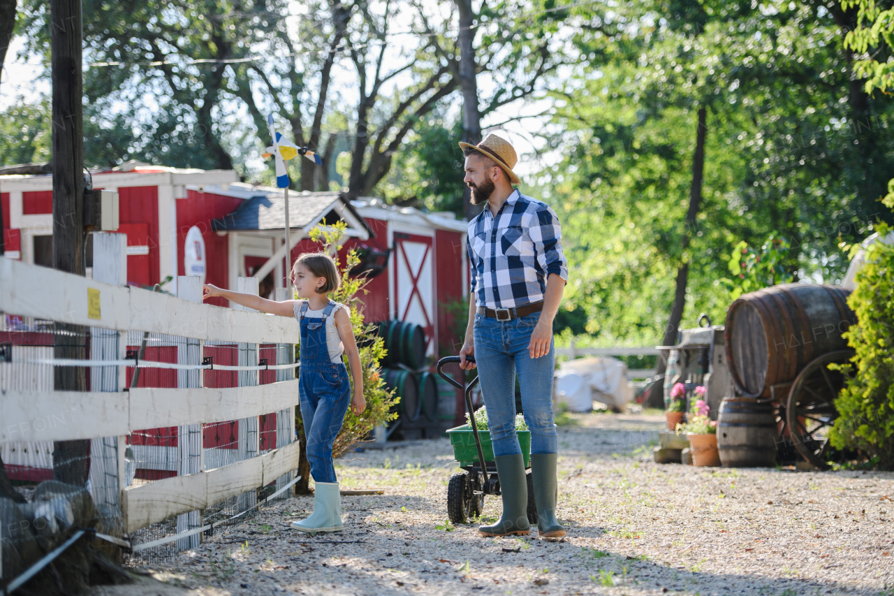 Farmer family, father and young daughter walking across family farm. Concept of multigenerational farming.