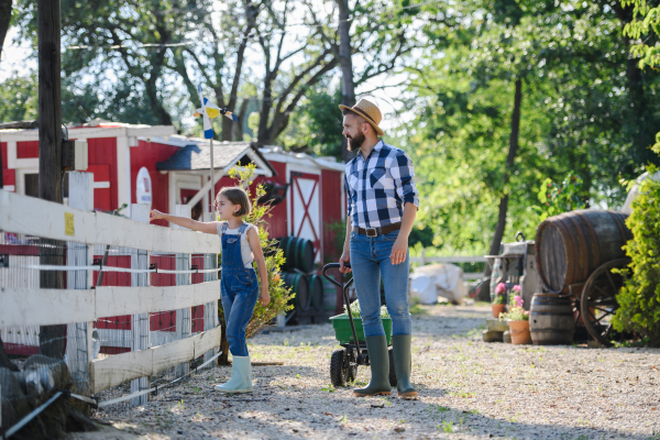 Farmer family, father and young daughter walking across family farm. Concept of multigenerational farming.