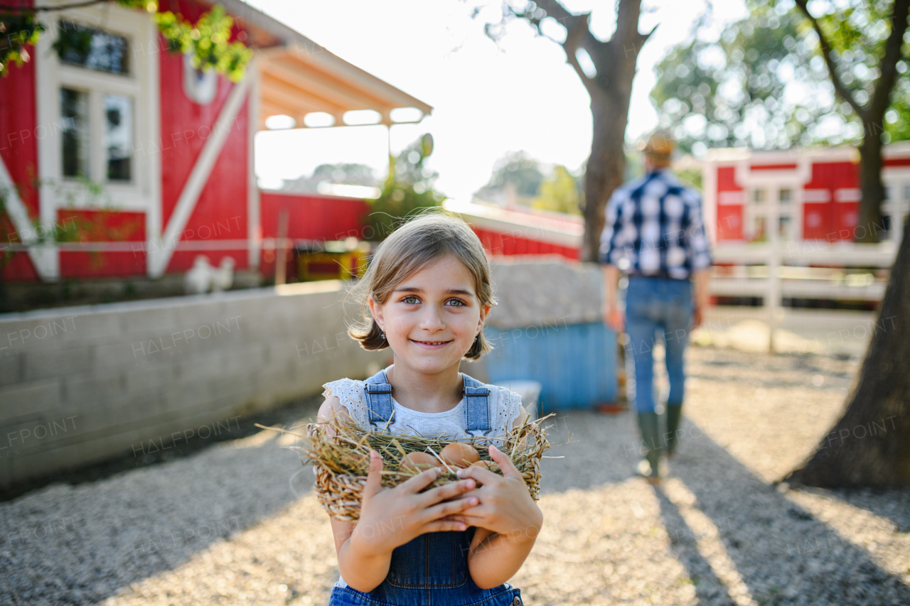 Beautiful young girl helping on family farm during summer, holding lavender plant in pot. . Future female farmer.