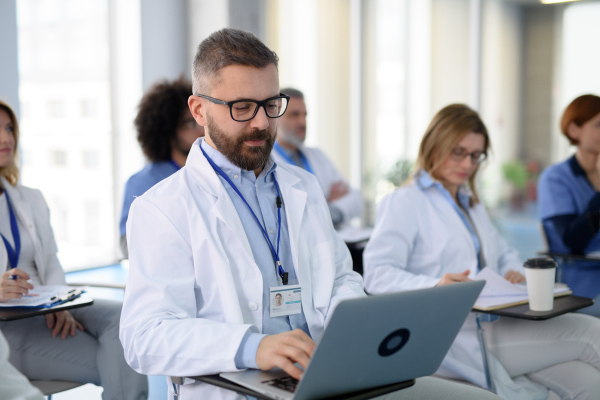 Group of doctors on conference, medical team sitting and listening presenter. Medical experts attending an education event, seminar in board room.