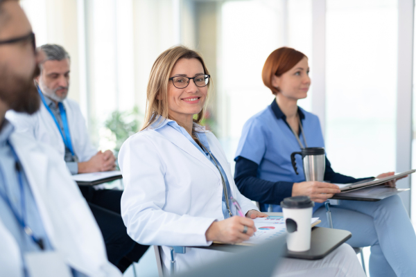 Group of doctors on conference, medical team sitting and listening presenter. Medical experts attending an education event, seminar in board room.