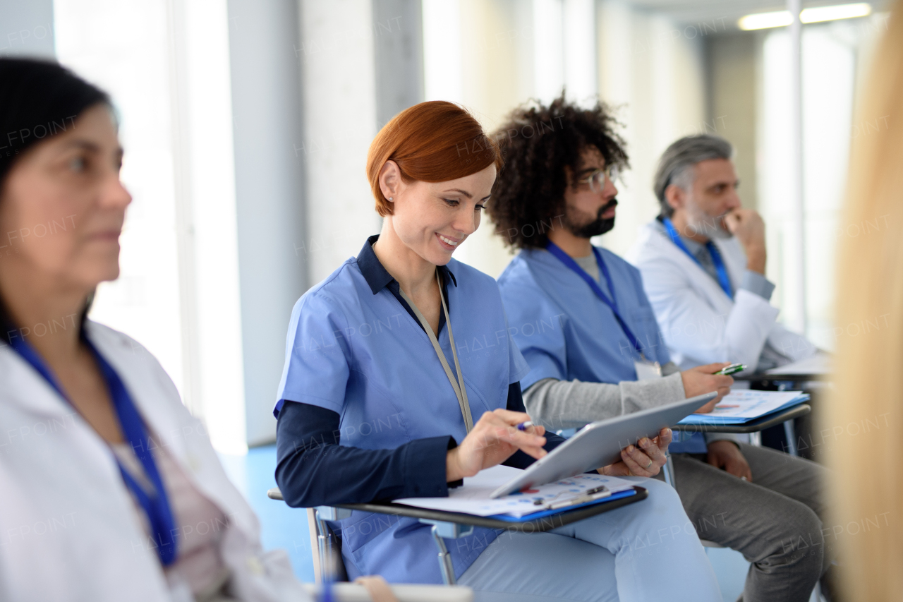 Group of doctors on conference, medical team sitting and listening presenter. Medical experts attending an education event, seminar in board room.