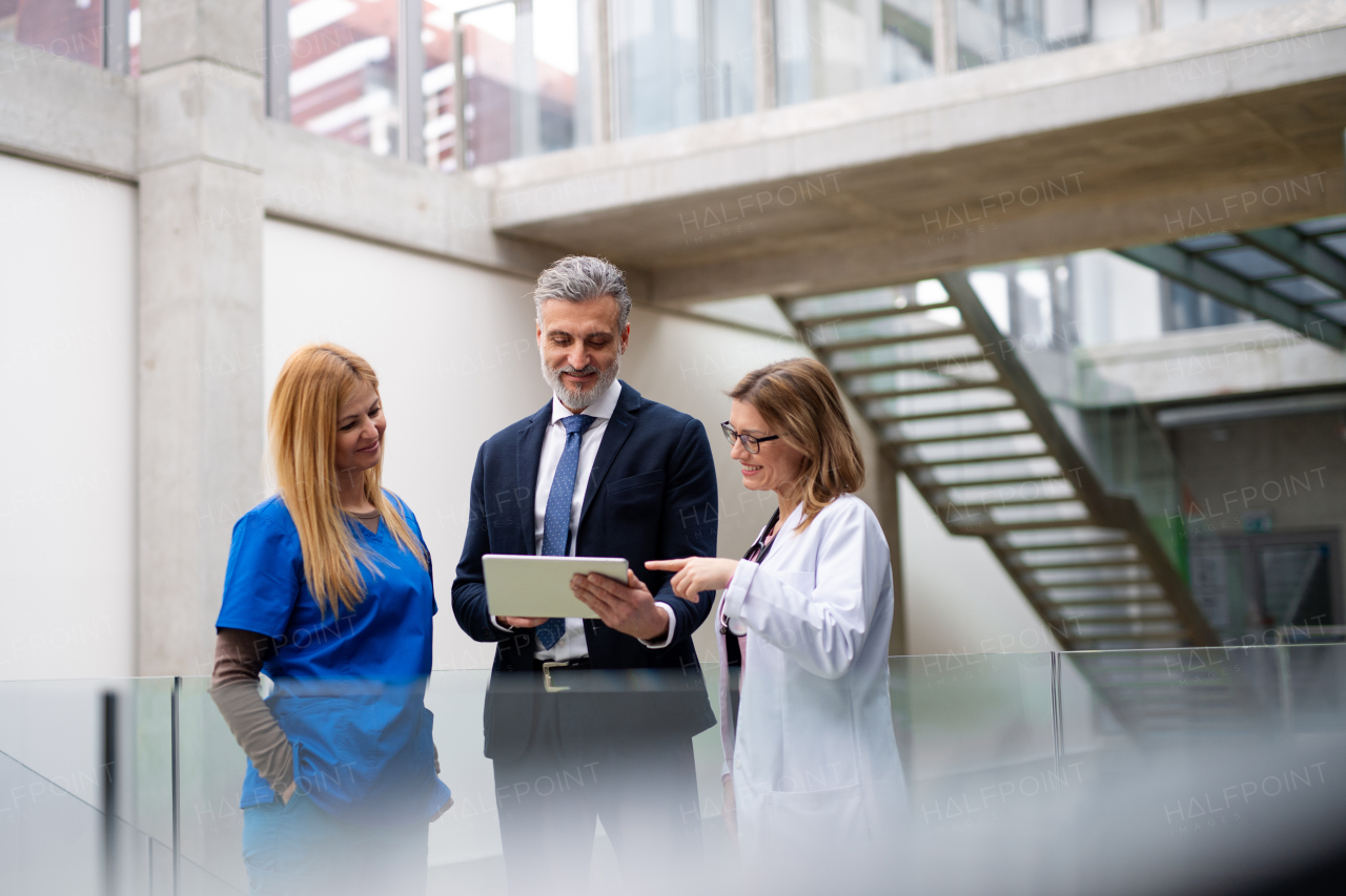 Doctors talking to pharmaceutical sales representative, presenting new pharmaceutical product. Hospital director, manager talking with doctors team.