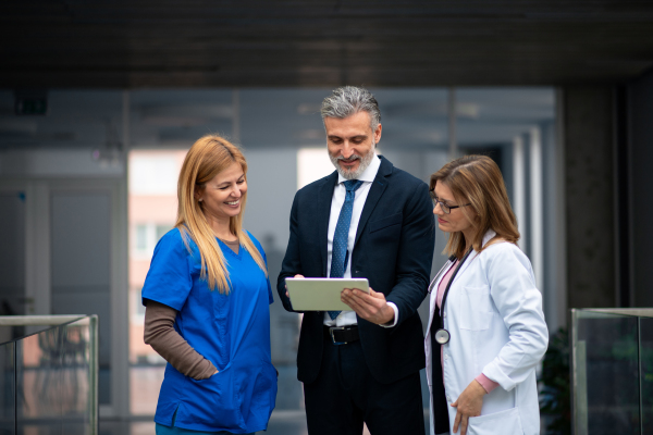 Doctors talking to pharmaceutical sales representative, presenting new pharmaceutical product. Hospital director, manager talking with doctors team.