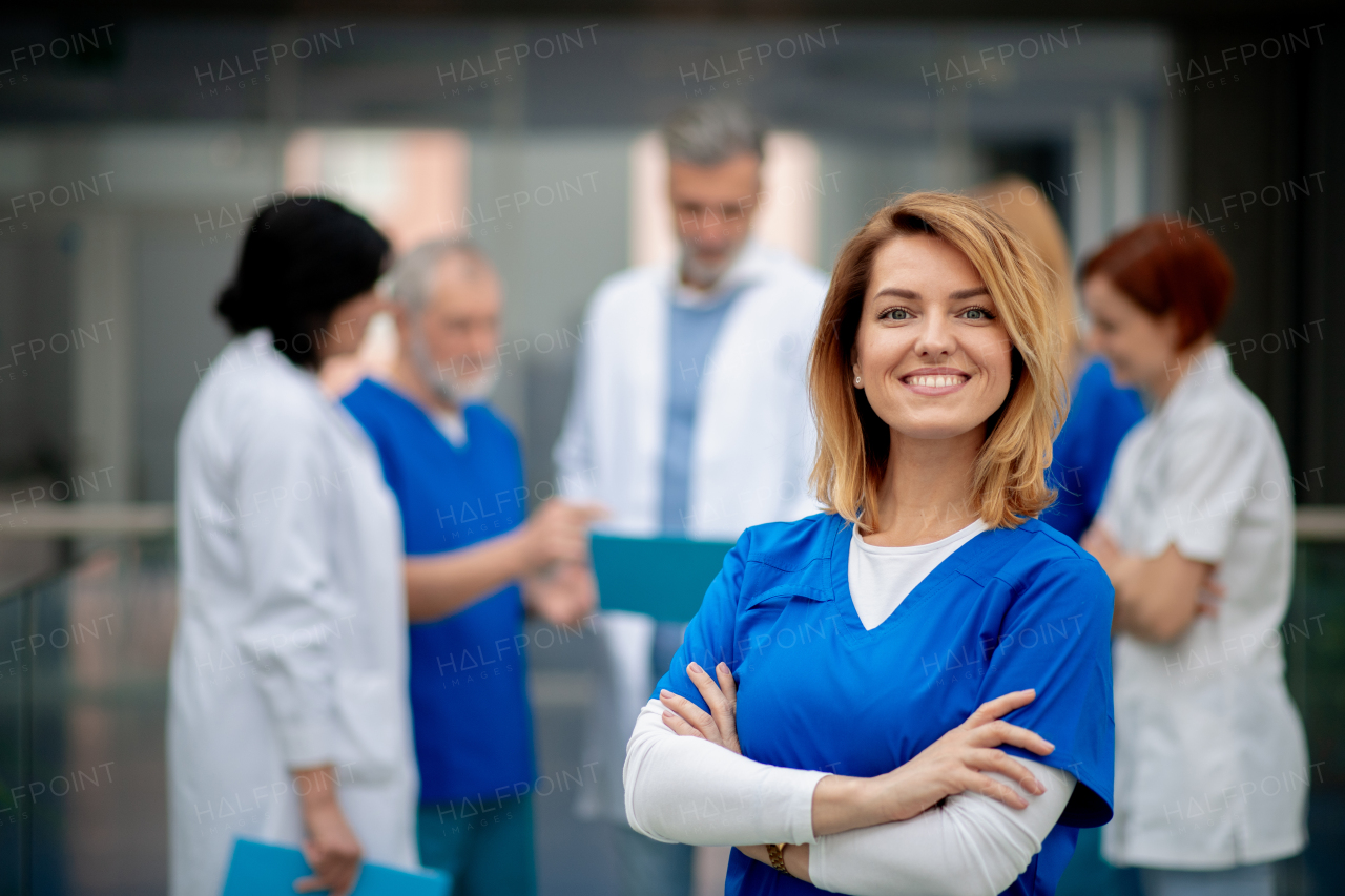 Portrait of beautiful female doctor standing in front of team of doctors. Colleagues, doctors team discussing patients diagnosis. in modern hospital, clinic.