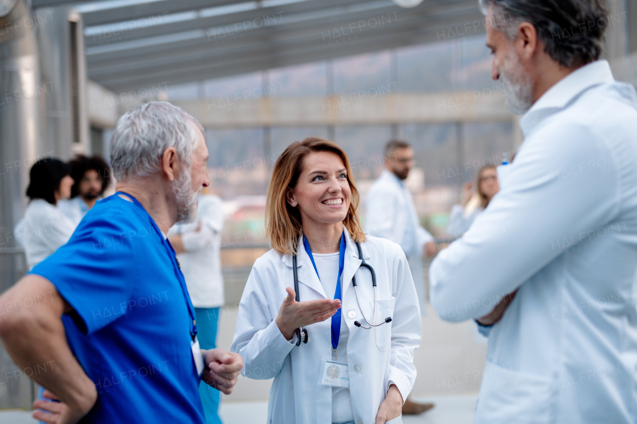 Group of doctors talking during conference, discussing research findings. Medical networking. Medical experts attending an education event, seminar in board room. Age and gender equity in healthcare.