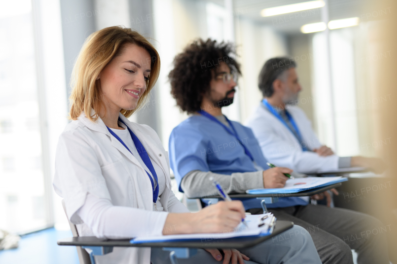 Group of doctors on conference, medical team sitting and listening presenter. Medical experts attending an education event, seminar in board room.