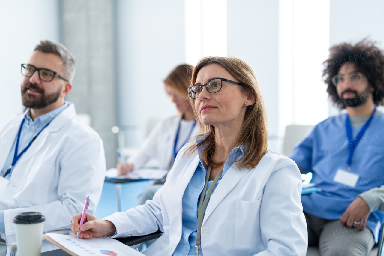 Group of doctors on conference, medical team sitting and listening presenter. Medical experts attending an education event, seminar in board room.