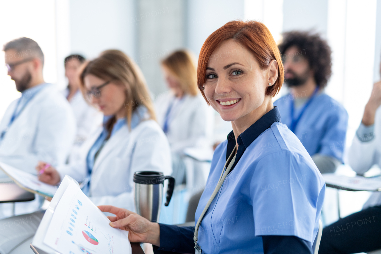 Group of doctors on conference, medical team sitting and listening presenter. Medical experts attending an education event, seminar in board room.