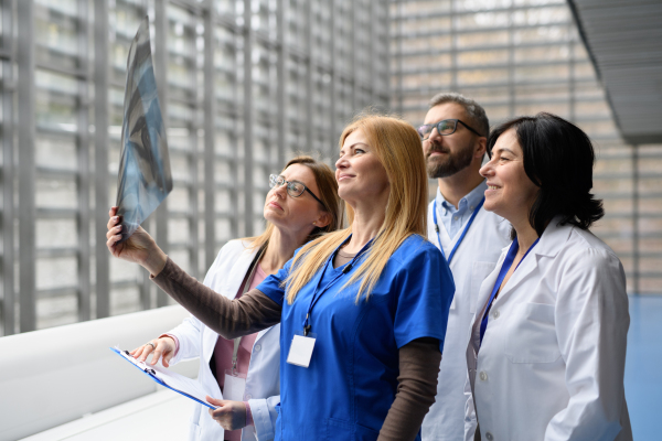 Group of doctors discussing X-ray scan, medical team discussing patients results, searching for problem and right treatments.